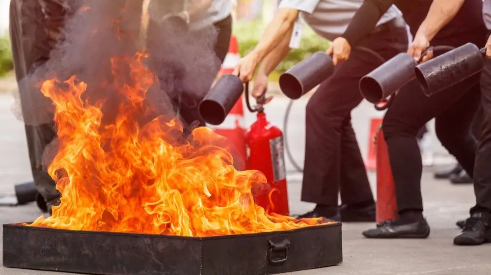 Participants practising fire extinguisher use during fire safety training