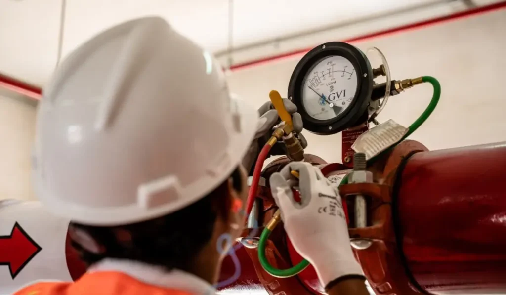 Technician testing and servicing a fire protection piping system